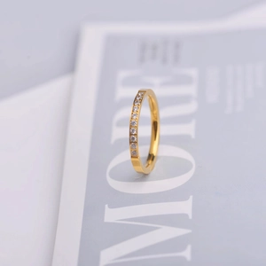Macro di un anello eternity dorato con cristalli trasparenti su uno sfondo di lusso