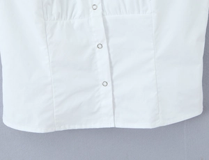 Detailed macro view of white shirt fabric with three silver metallic snap buttons