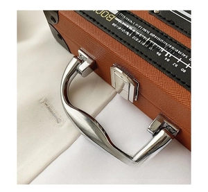Detail of vintage radio box bag with scale print and polished silver metal handle