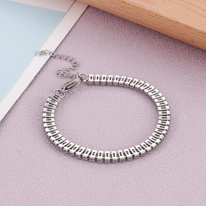 Détail du bracelet à maillons carrés argentés avec fermoir mousqueton et chaîne d'extension