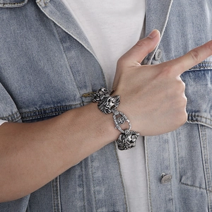 Detail of masculine silver lion head bracelet on wrist with heavy duty steel links