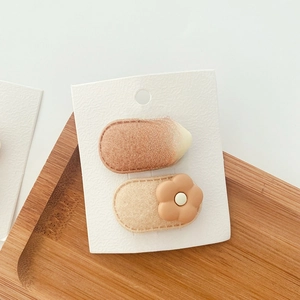 Milk tea color floral felt hair clips for kids on a textured display card