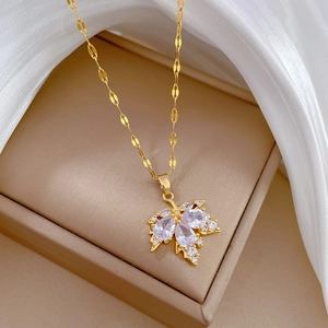 Detailed macro view of a gold maple leaf pendant with clear zircons on a jewelry box