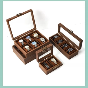 Detail of luxury walnut wood watch boxes with glass lid and soft velvet cushions