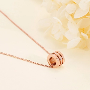 Close-up of rose gold waist pendant necklace with crystals on soft beige background