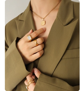 Detail der 18K vergoldeten Halskette mit quadratischem Anhänger und Ringen am Modell