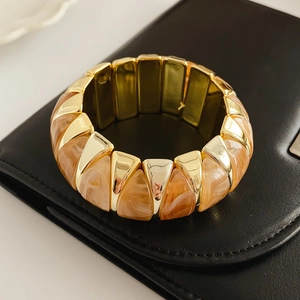 Detailed close-up of a vintage elastic bracelet with amber resin and gold metal segments