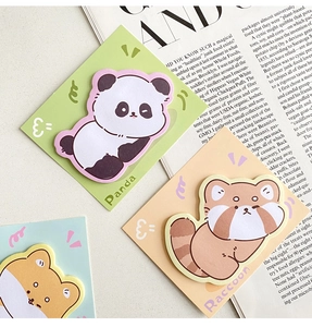 Detail view of cute panda and raccoon cartoon sticky notes on a light desktop
