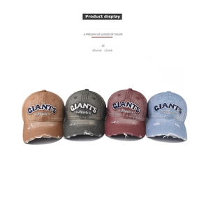 Detail showing four colors of distressed denim baseball caps with GIANTS embroidery