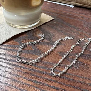 Close-up of minimalist 925 sterling silver twisted rope and beaded chain bracelets