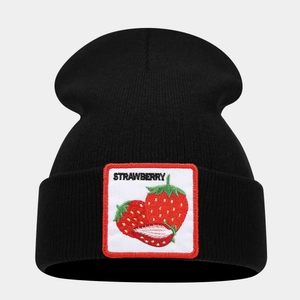 Close-up of black knitted beanie featuring a white patch with embroidered red strawberries