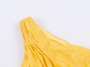 Detail shot of yellow floral jacquard fabric with pleated shoulder and ruffle design