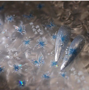 Close-up of butterfly nail art stickers with iridescent blue laser finish and floral designs