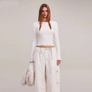 Top in maglia bianca a maniche lunghe con pantaloni cargo e catena in vita