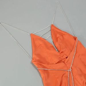 Détail des bretelles en strass et du tissu satiné orange sur cette combinaison