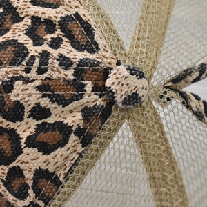 Macro view of leopard print fabric textures and breathable mesh on a baseball cap