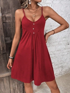 Detail view of the red knit dress with a deep V-neck and three white decorative buttons