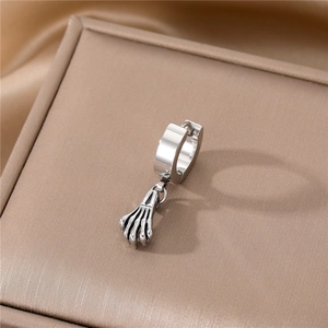 Macro shot of silver stainless steel earring with gothic skull hand claw pendant detail