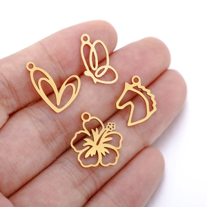 Golden metal bird and flower charms shown on hand for size scale and detail