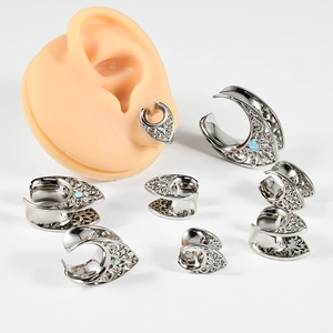 Hollow stainless steel ear gauges with blue opal inlay in various sizes on white background