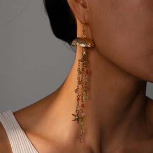 Close-up of beach style jellyfish and starfish drop earrings worn by a female model