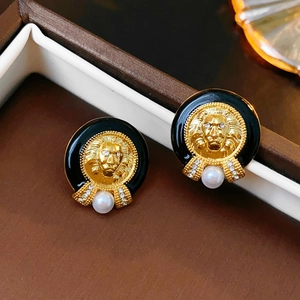 Vintage gold lion head stud earrings with black enamel and white pearl drop accents