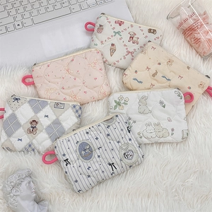 Detailed view of quilted cotton mini pouches with diverse cartoon patterns and zipper strap