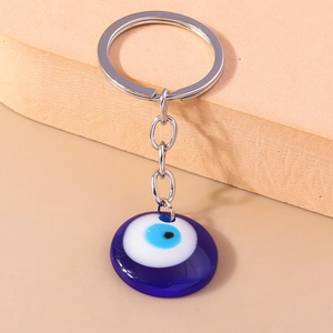 Detailed close-up of the blue Evil Eye charm with silver metal keyring on a soft background