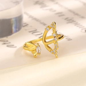 Exquisite gold zircon butterfly and arrow open ring on a vintage book page backdrop