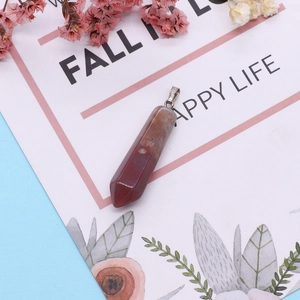 Détail d'un pendentif en pierre hexagonale brun-rouge avec fermoir sur carte florale