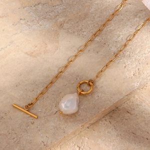 Detail of gold toggle clasp and baroque freshwater pearl on stainless steel square chain