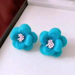 Elegant blue floral stud earrings with soft wool texture and pink stamen detail