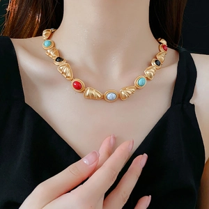Close-up of vintage gold-tone necklace with colorful beads on a model's neck