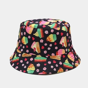 Close-up of cute cartoon cupcake and cherry blossom patterns on a black bucket hat