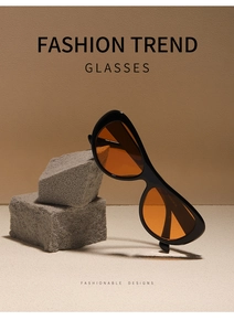 Detail of vintage black oval sunglasses with orange lenses on a natural stone base