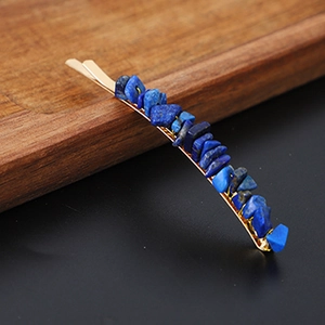 Detail of blue natural crystal stones embedded on a golden metal minimalist hair clip