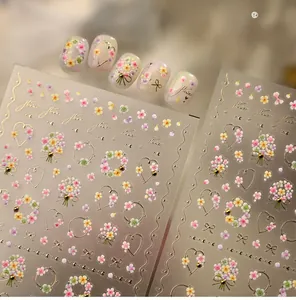 Detail of 5D embossed floral nail stickers featuring colorful flowers and golden text