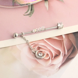 Detail of silver industrial barbell with iridescent beads and moon star chain pendant