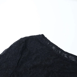 Détail de la dentelle noire élégante et du col diagonal chic sur la robe à manches longues