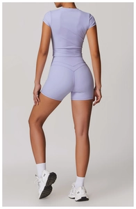 Vista posteriore di pantaloncini yoga a vita alta e top a maniche corte lilla chiaro