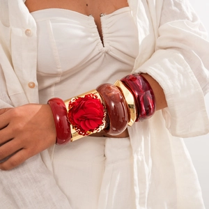 Vintage chunky resin bangle set with red and amber patterns and large gold floral bracelet