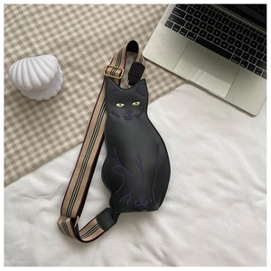 Detail of cute black cat chest bag with striped fabric strap on a minimalist background