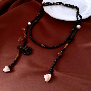 Ethnic beaded long necklace with tiger eye stones and shell pendants on velvet