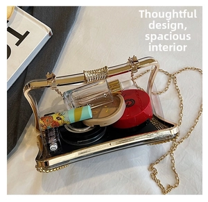 Detailed view of transparent acrylic evening clutch bag with gold trim and chain strap
