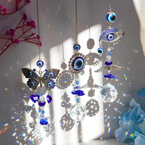 Three evil eye suncatchers casting rainbow light reflections with crystal prism balls