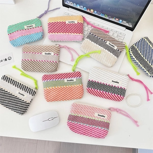 Flat lay of colorful handmade knitted striped makeup bags with metal zippers and wristlets