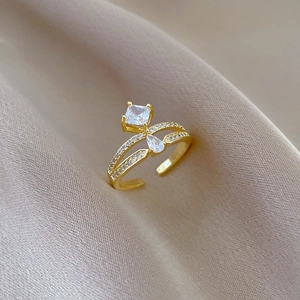 Detail of adjustable gold crown ring with square and teardrop zircon on silk fabric