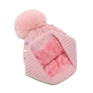 Detalle de gorro de punto rosa con forro polar suave y pompón de piel sintética