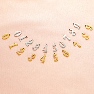 Detailed view of silver and gold stainless steel number pendants for custom jewelry