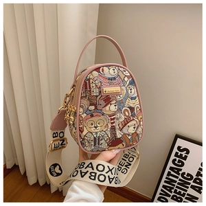 Detail of teddy bear jacquard fabric handbag with wide monogrammed shoulder strap